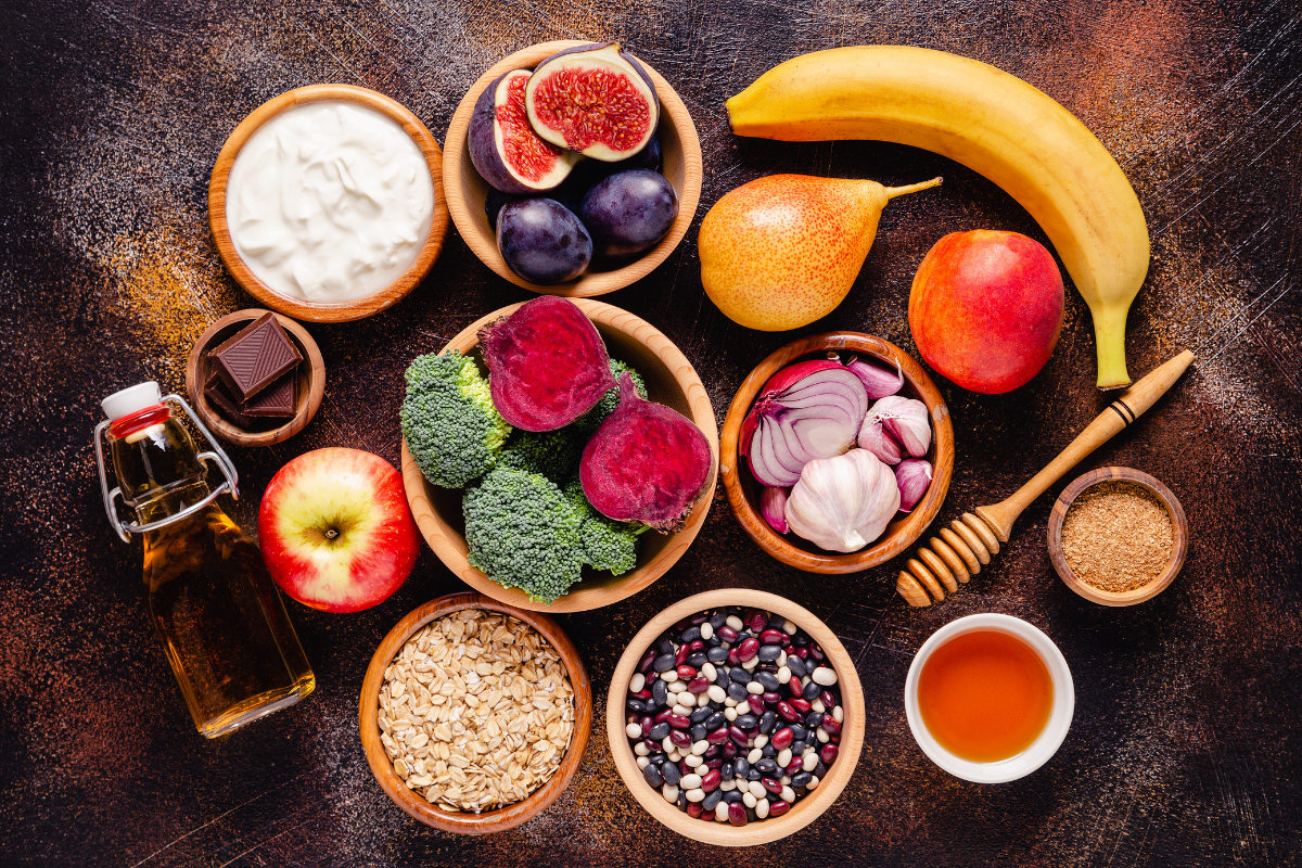 A variety of gut-friendly foods arranged on a dark rustic surface.