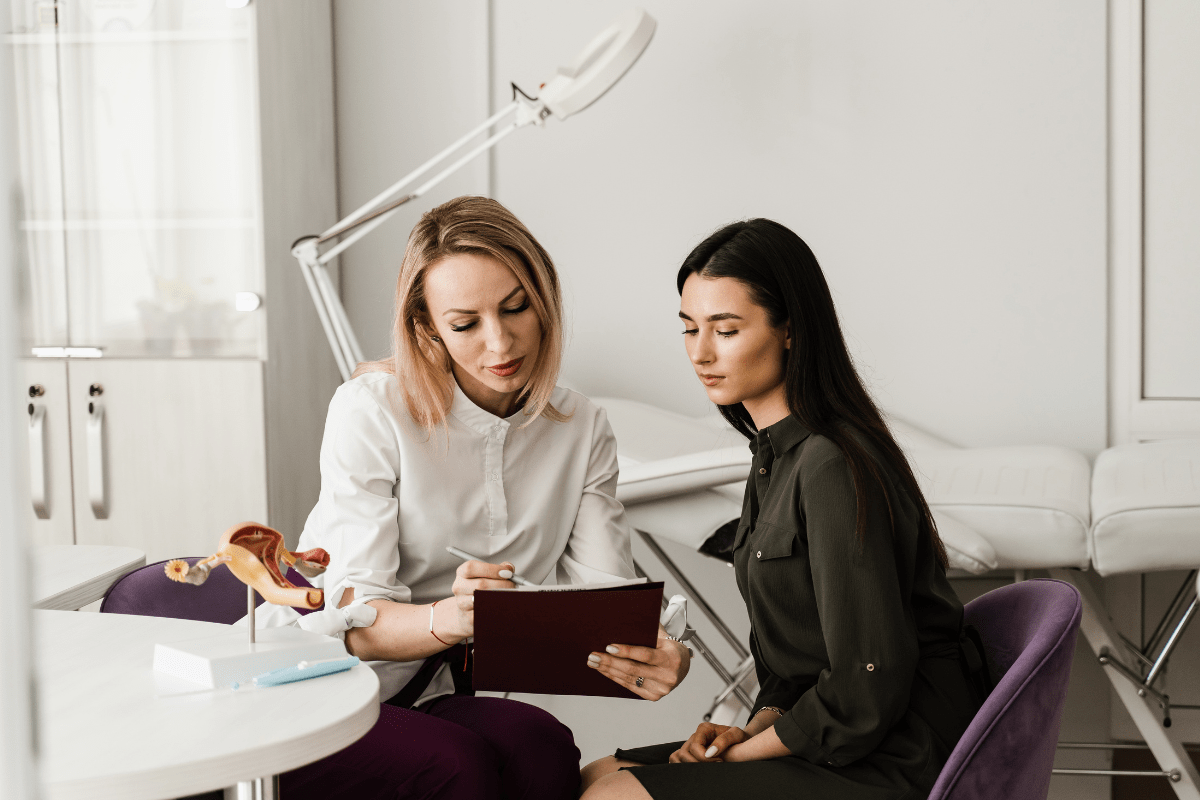 Healthcare professional discussing information with a patient in a medical office setting.