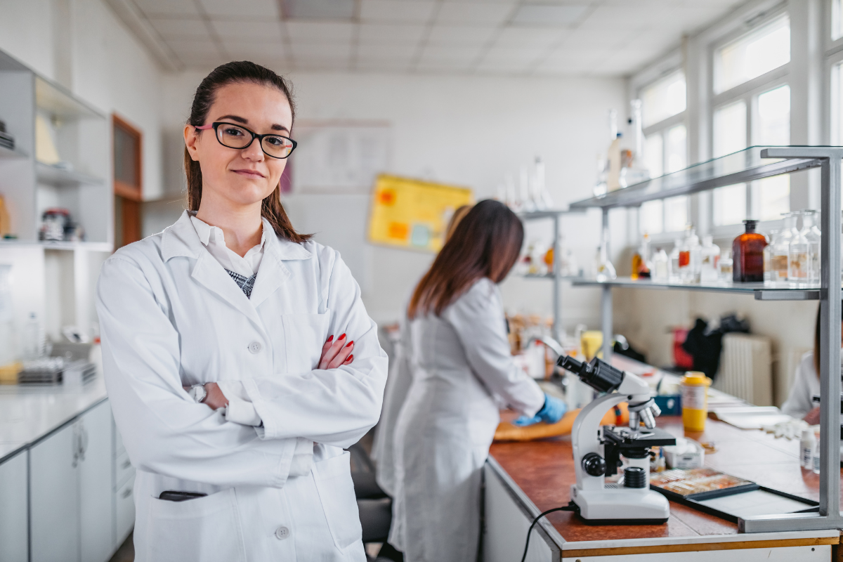 Female scientist in lab coat standing in longevity research laboratory.