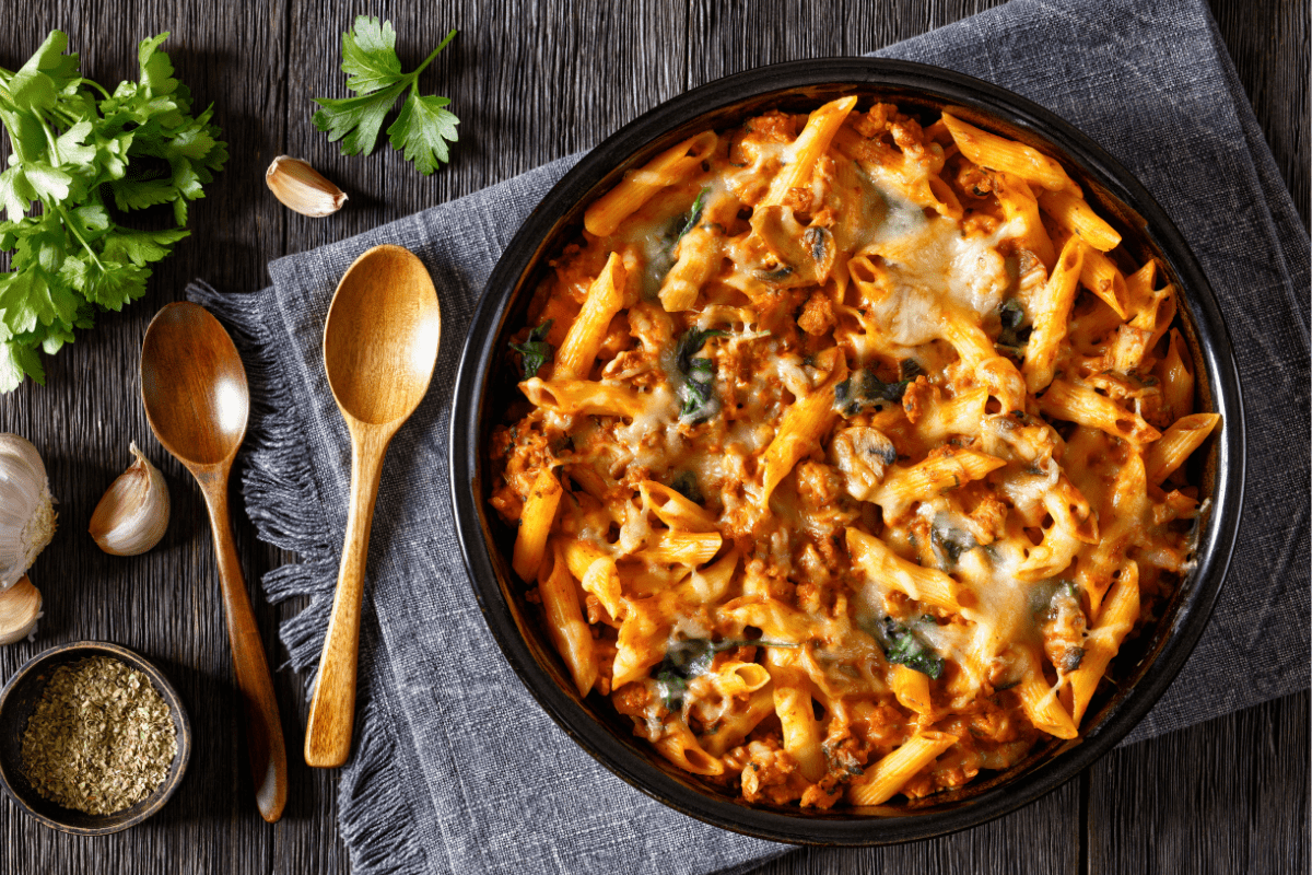 Baked pasta with a golden, cheesy crust, served in a black dish.