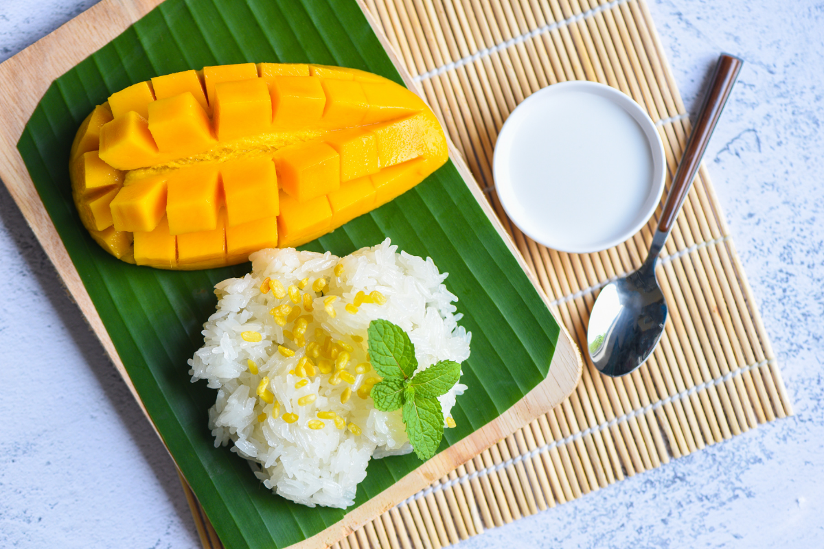 Thai sticky rice with mango served on banana leaf.