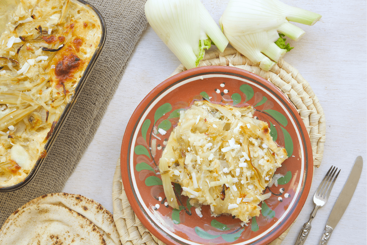 Baked fennel dish served on a plate with grated cheese.
