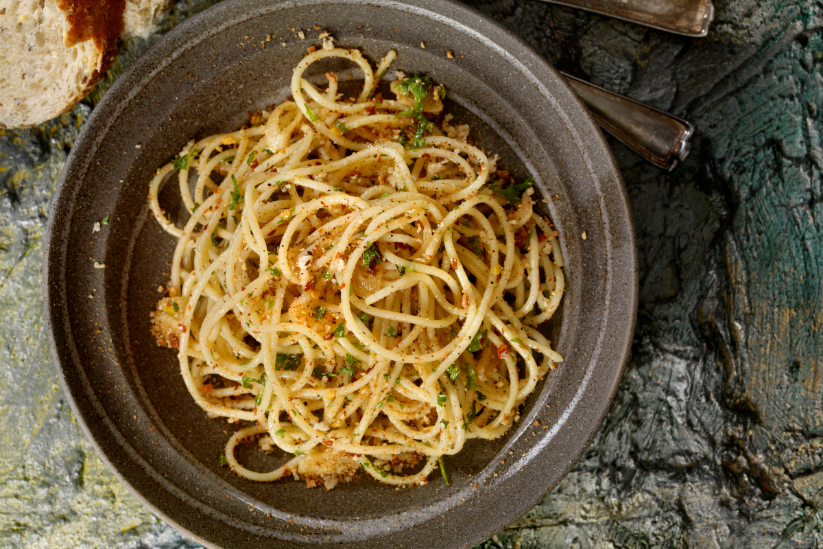 Spaghetti aglio e olio in rustic grey bowl.