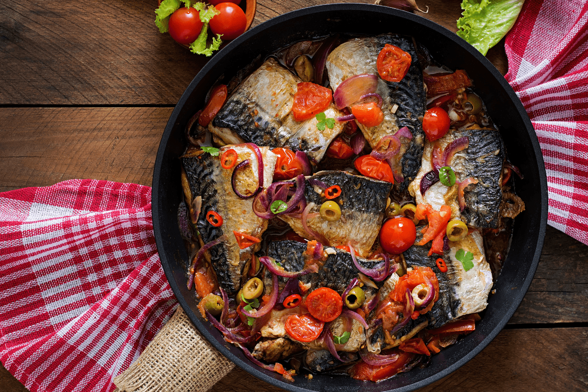 Mediterranean-style mackerel fillets in a skillet.